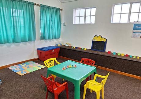 A bright Stargazers ECD classroom with small tables, chairs and learning materials